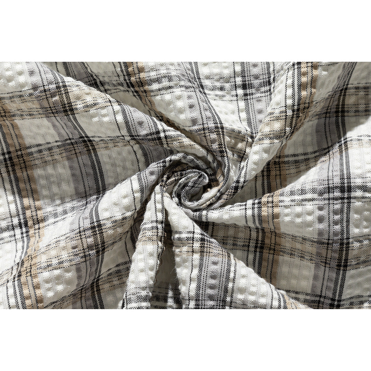 Close-up showing the cream shirt's raised textured fabric and black, gray, and tan plaid pattern.