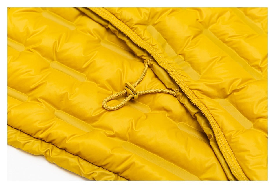 Close-up of a mustard-yellow padded jacket with a cord loop and toggle beside the front placket.