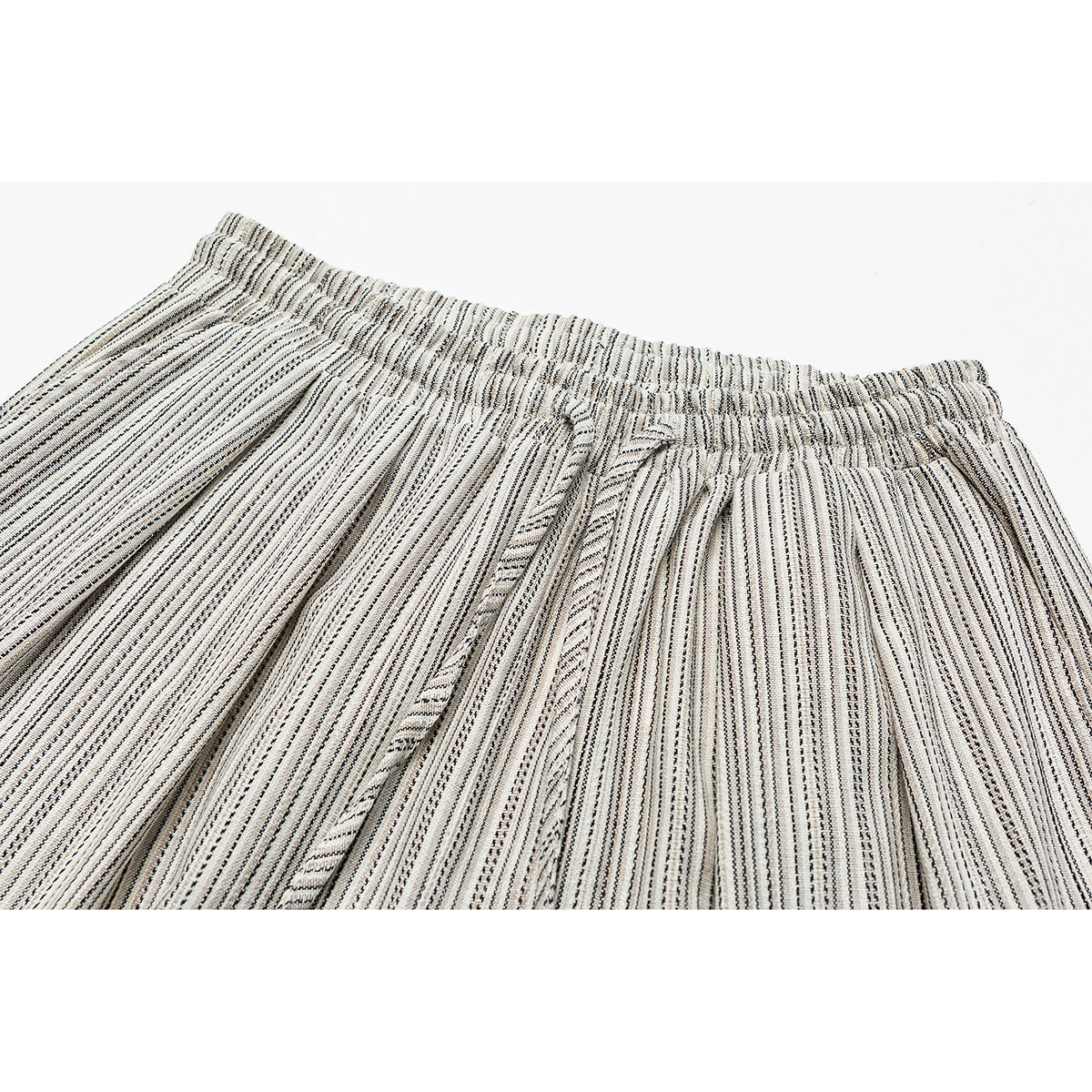 Close-up of cream-and-black striped trousers showing the gathered elastic waistband and matching drawstring.
