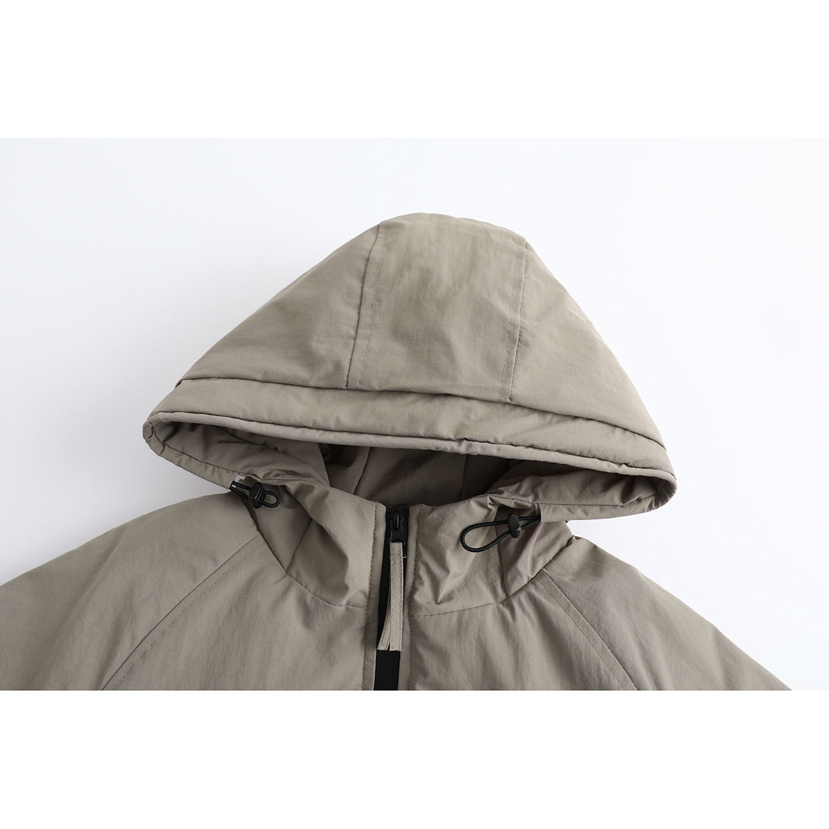 Close-up of a taupe jacket hood, showing black drawcord toggles and a front zipper.