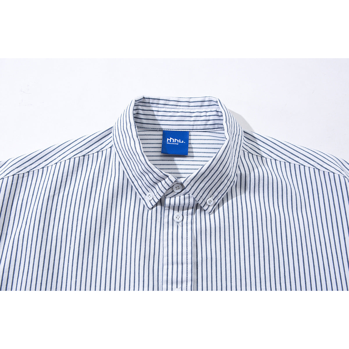 Close-up of a white shirt collar with thin blue vertical stripes, button-down points, and a blue neck label.