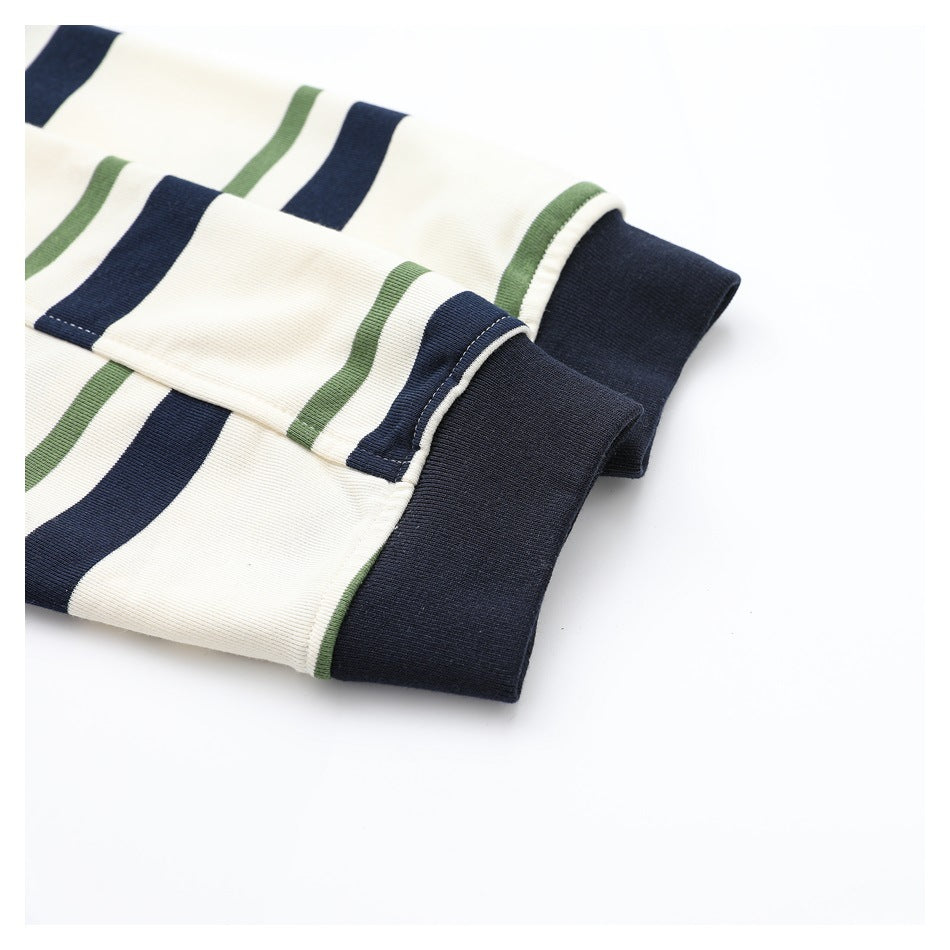 Close-up of folded striped knit fabric and a wide navy cuff or hem with visible stitching.