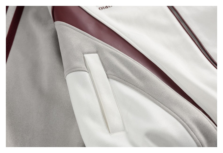 Close-up of an ivory and gray jacket showing a pocket, curved panels, and a burgundy accent stripe.