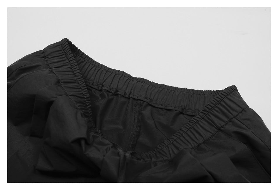 Interior close-up of black shorts showing the gathered elastic waistband and center seam.