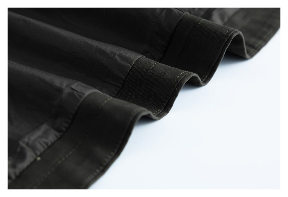 Close-up of the black garment hem with wide stitched bands and a folded edge.