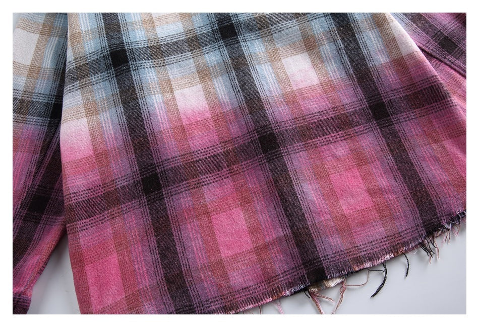 Close-up of pink and dark plaid shirt fabric with a frayed hem.