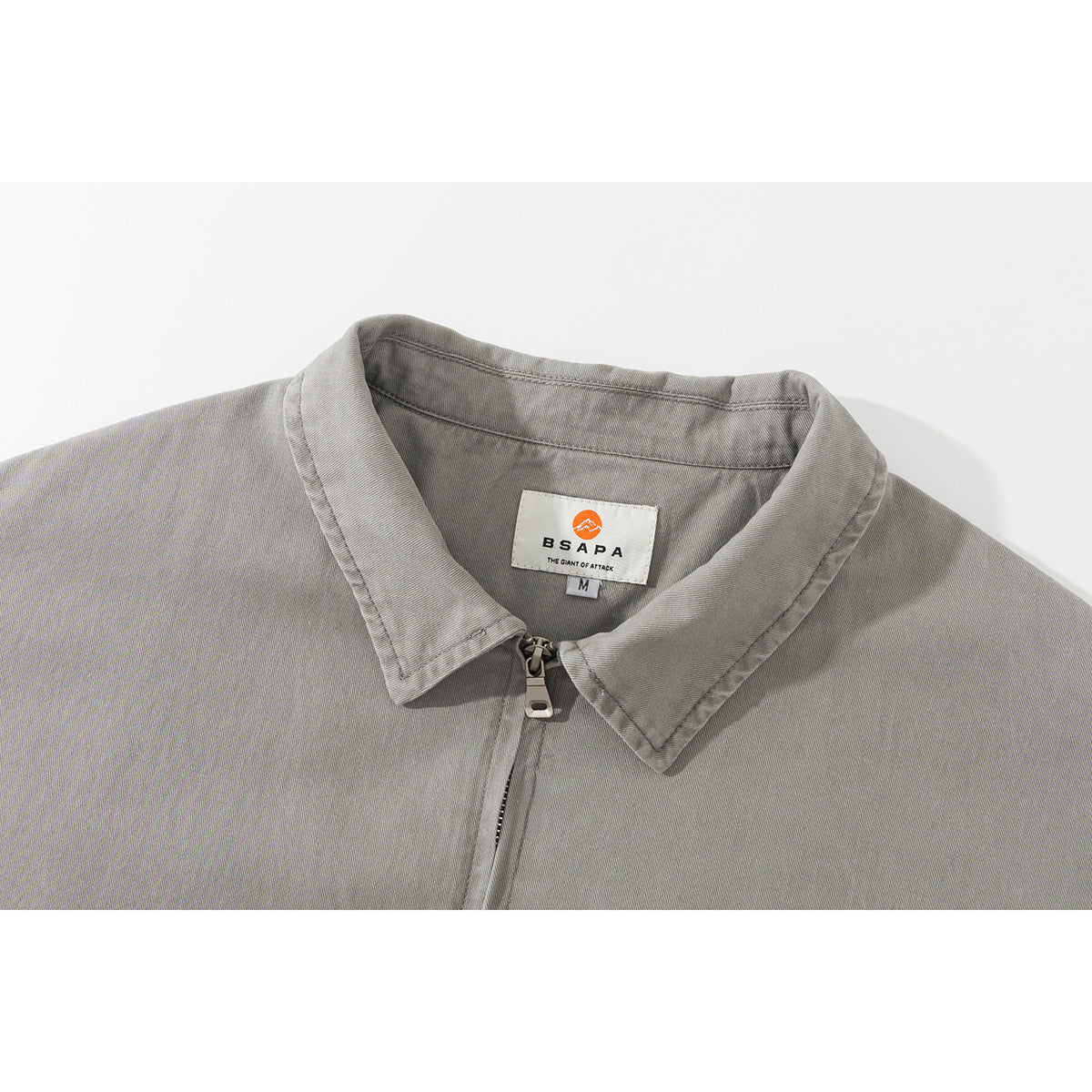 Close-up of a gray jacket collar with a zipper and a sewn-in brand label.