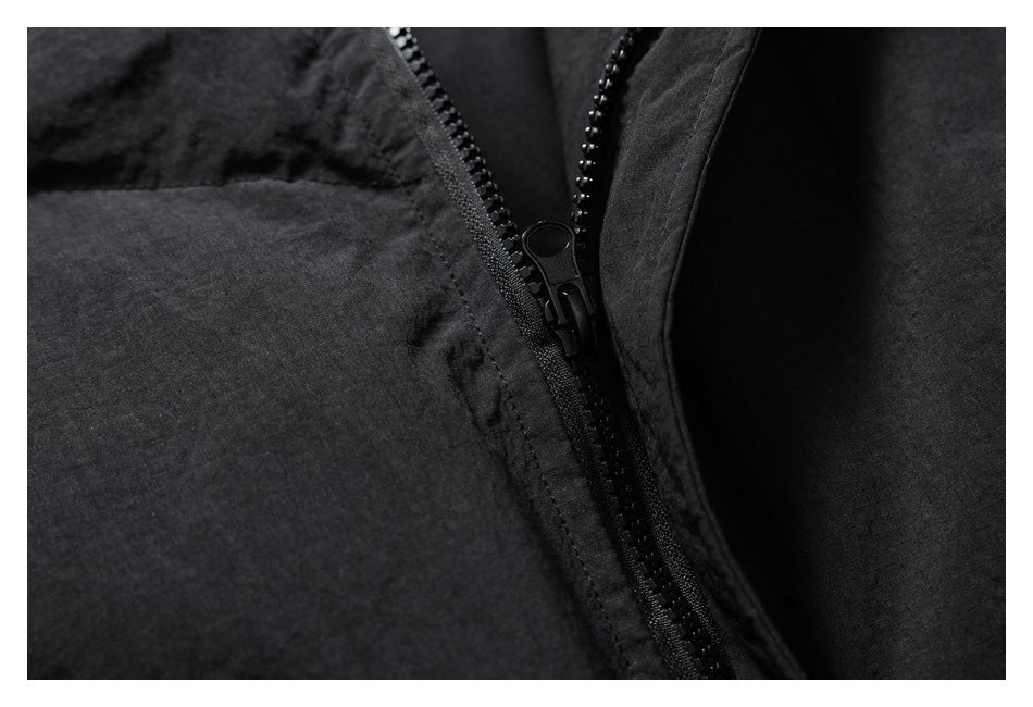 Close-up of the black jacket's front zipper and surrounding fabric.