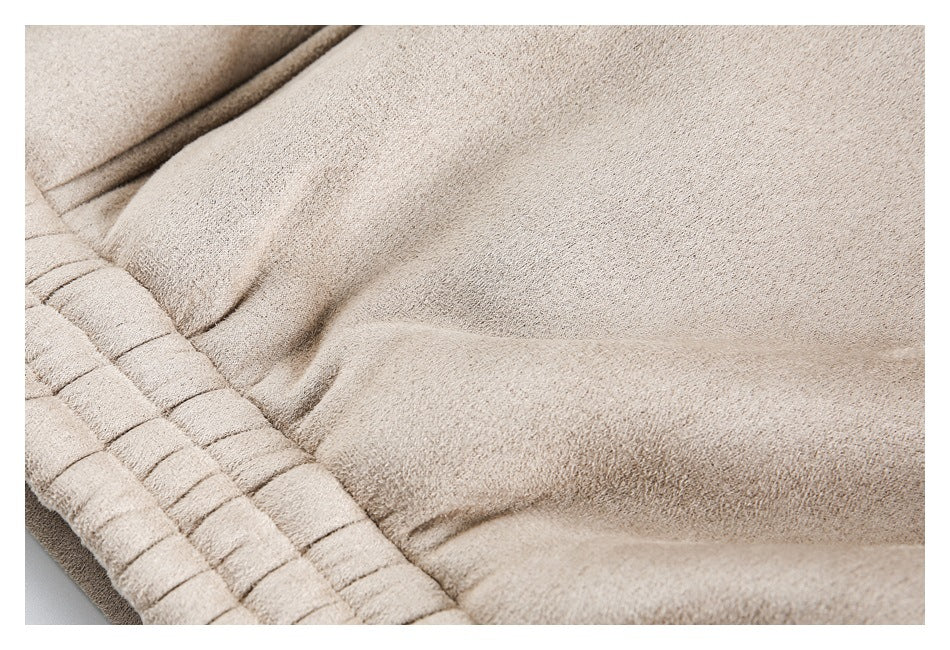 Close-up of beige garment fabric and gathered, stitched edge details.