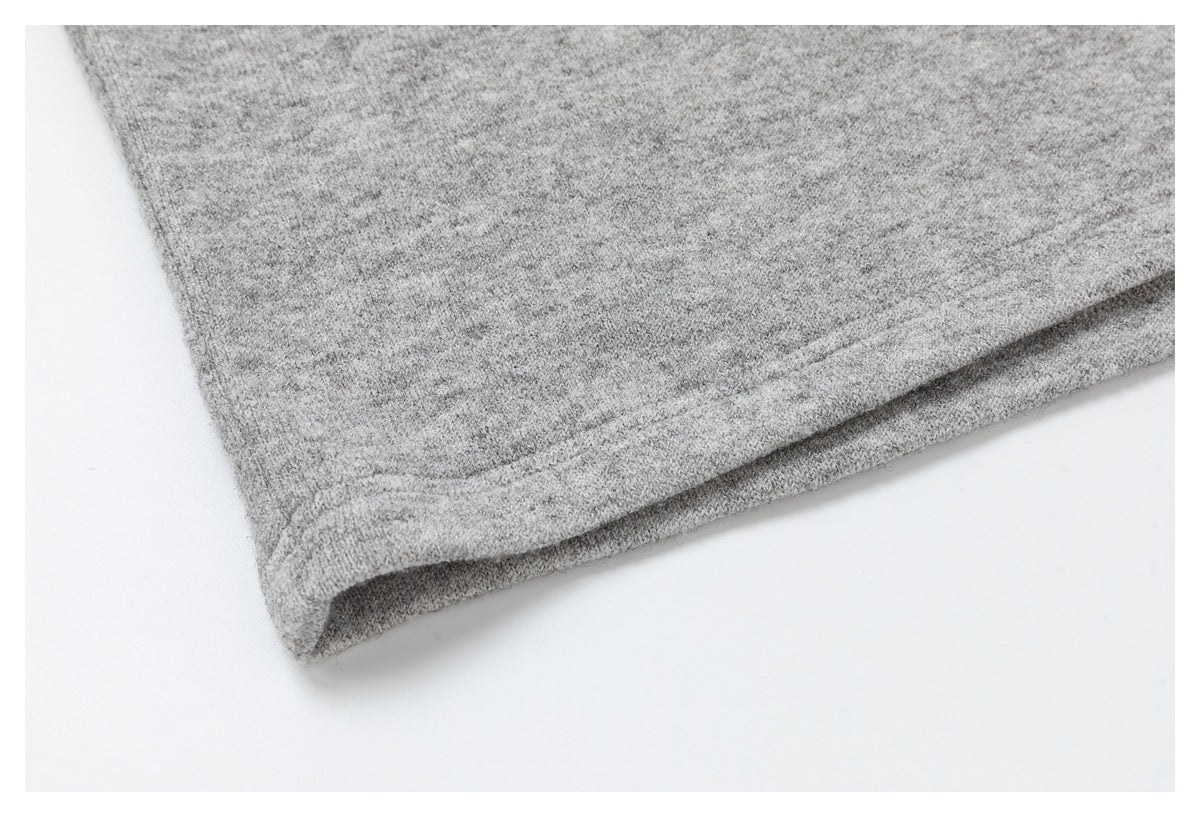 Close-up of the stitched hem on a heather gray knit garment.