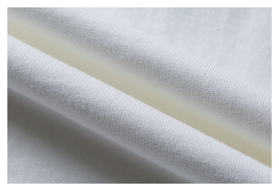 Macro view of white T-shirt fabric folded to show its knit texture.