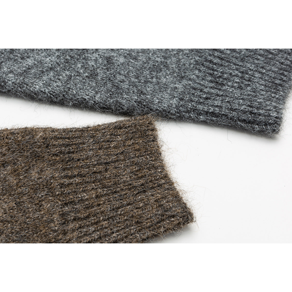 Close-up of gray and brown knit garment sections, showing their textured edges.
