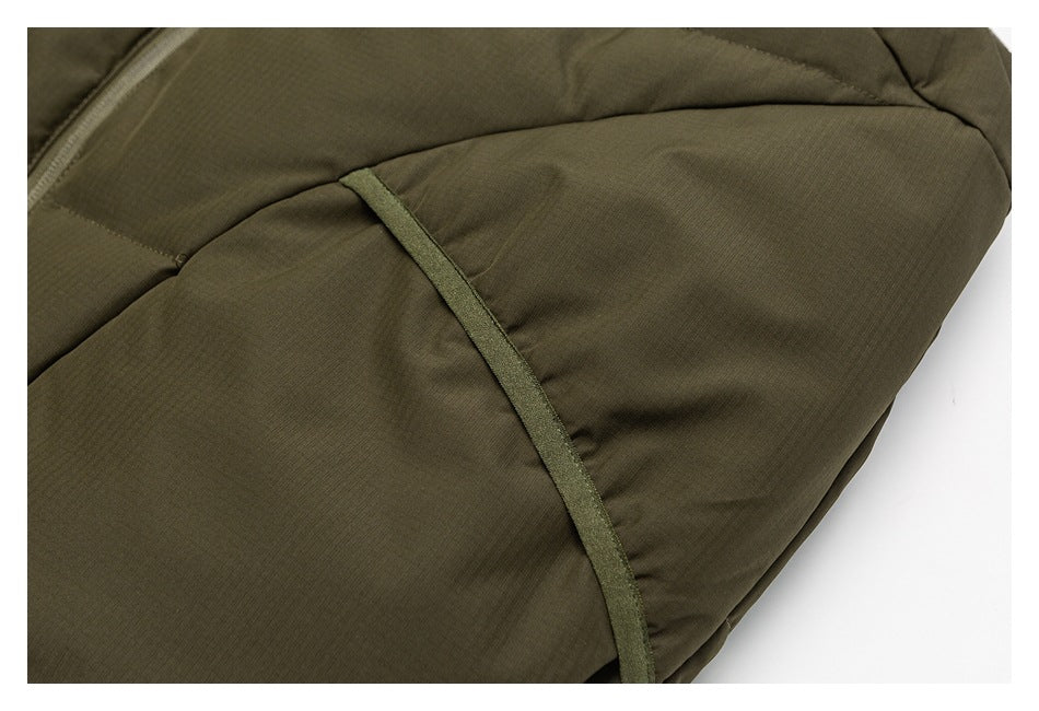 Close-up of olive padded jacket fabric, curved seams, and narrow trim.