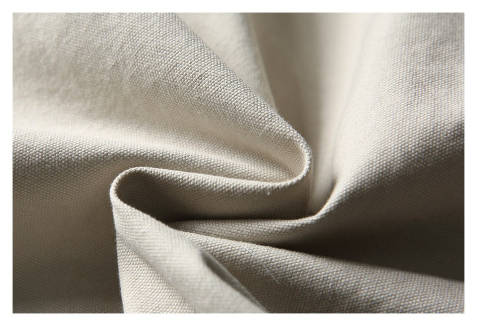 Close-up of pale beige woven fabric gathered into soft folds, highlighting its small, even weave.