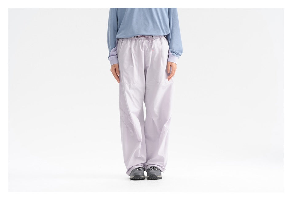 Front view of a model wearing pale lavender wide-leg drawstring pants and a light blue top.