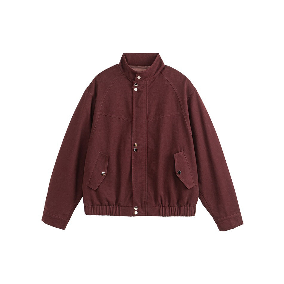 Burgundy red stand-collar bomber jacket flat lay with snap placket, flap pockets and elastic hem