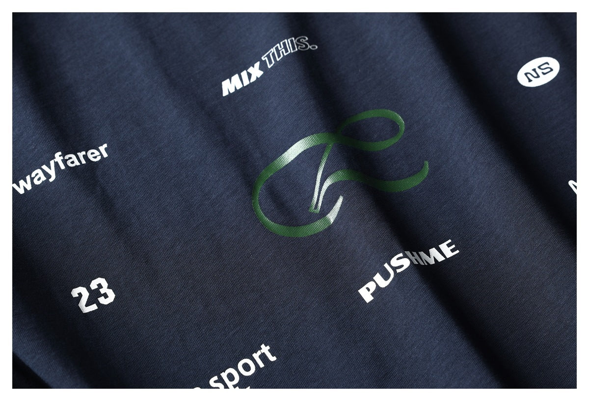 Close-up of a dark navy garment with assorted white English lettering and a green graphic print.
