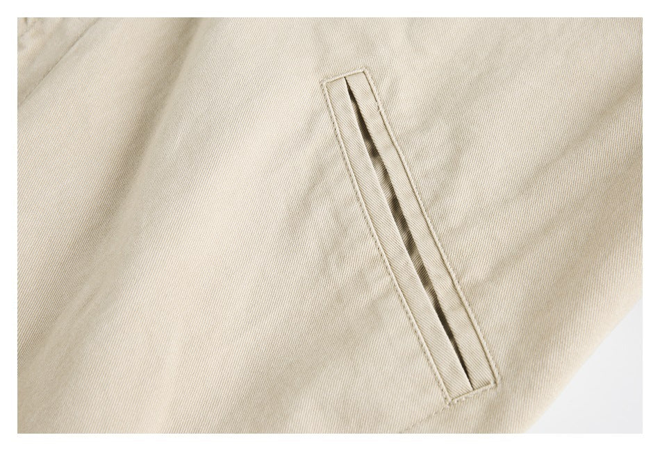 Close-up of a long, narrow pocket opening on beige jacket fabric.