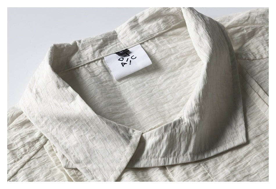 Close-up of an off-white shirt's wide collar and attached neck label.