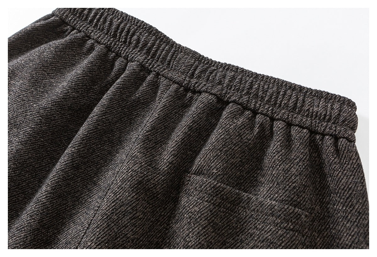 Close-up of charcoal gray marled pants showing the elastic waistband and front pocket opening.