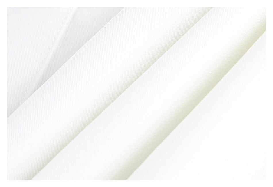 Close-up of white garment fabric arranged in diagonal folds.