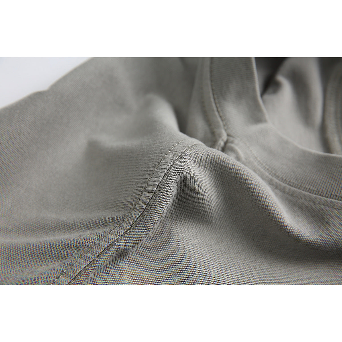 Close-up of a gray T-shirt showing the collar, shoulder seam, and fabric texture.