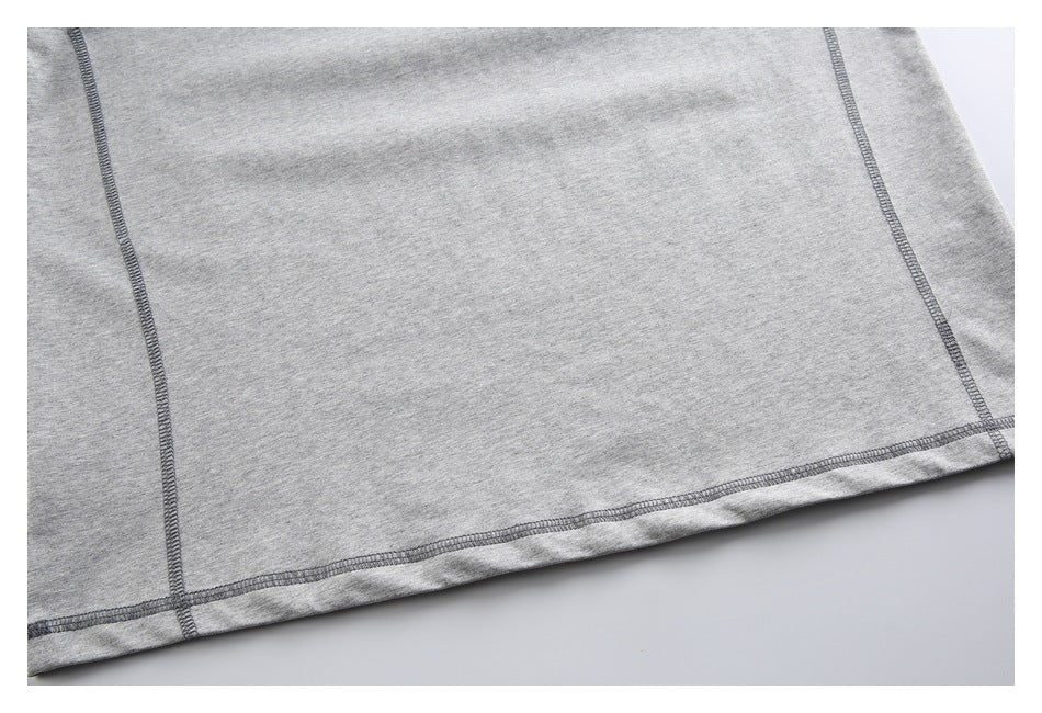 Close-up of the heather-gray shirt’s lower hem and vertical overlock seams.