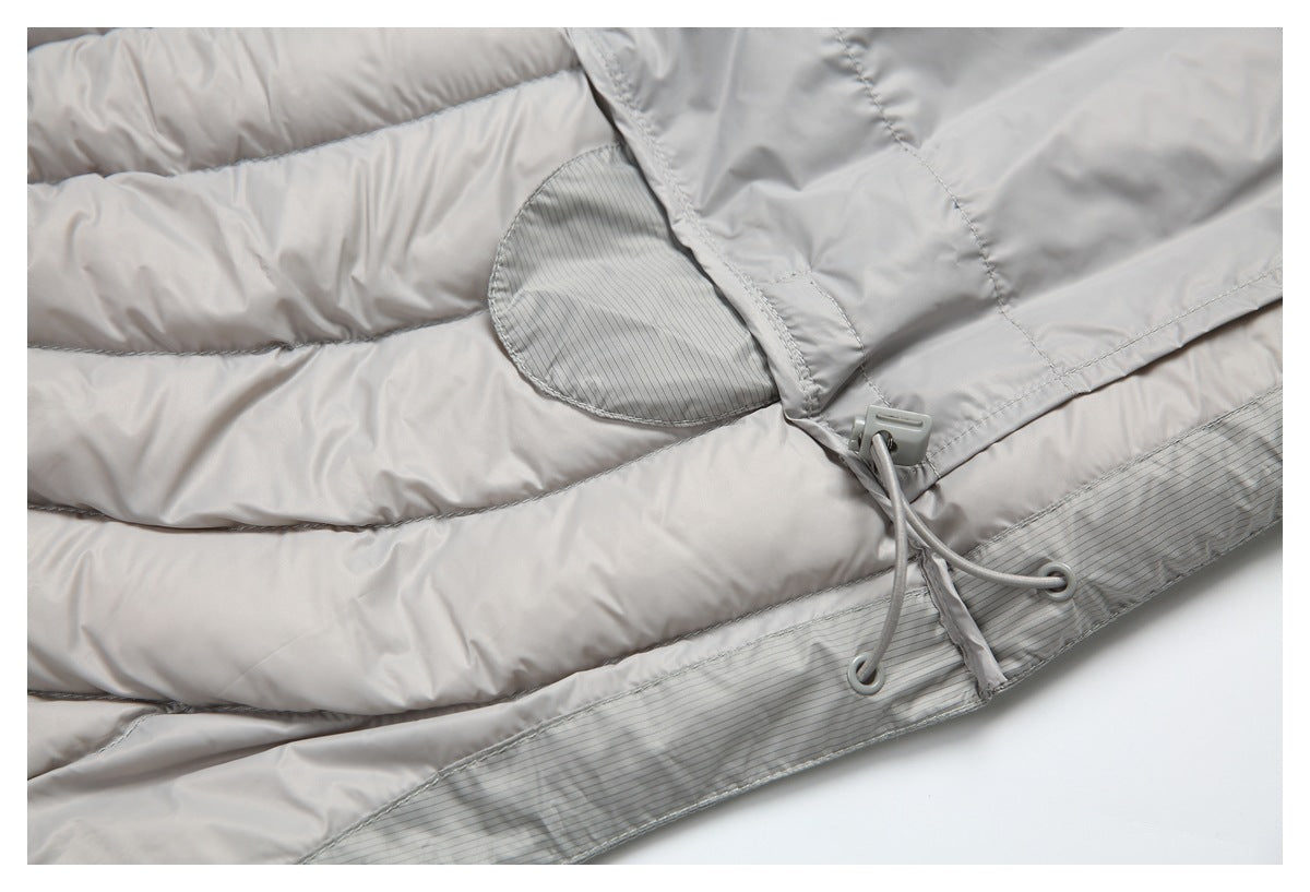 Close-up of the light gray puffer jacket hem with a cord-and-toggle adjuster and pinstriped trim.