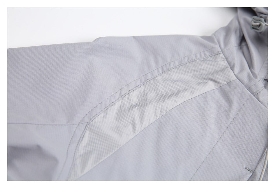 Close-up of a pale gray jacket shoulder seam and curved, textured contrast panel.