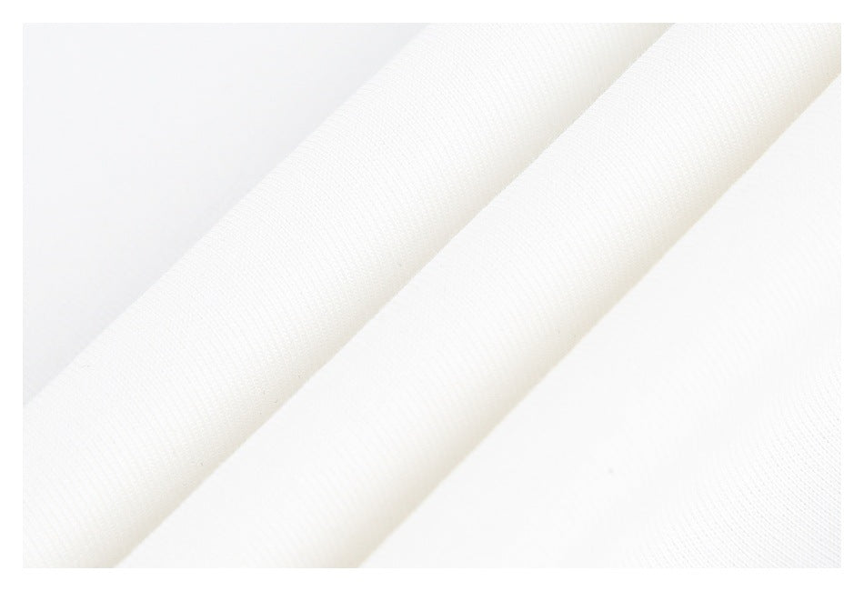 Close-up of folded white knit fabric showing the garment's finished edge.