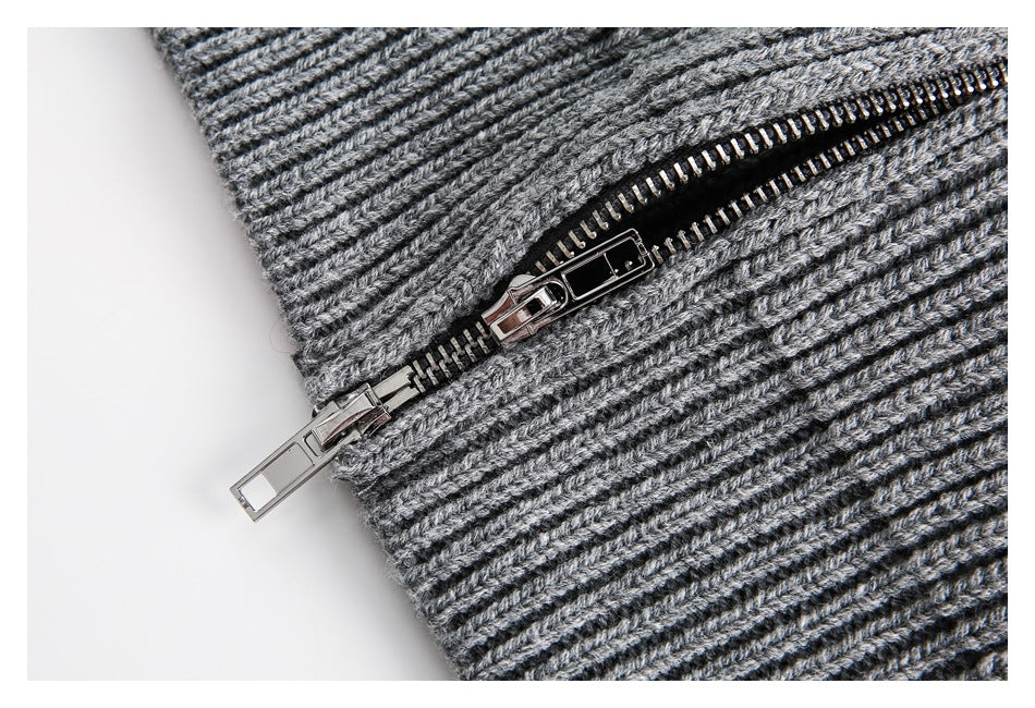 Close-up of the gray rib-knit sweater's metal zipper and knit texture.