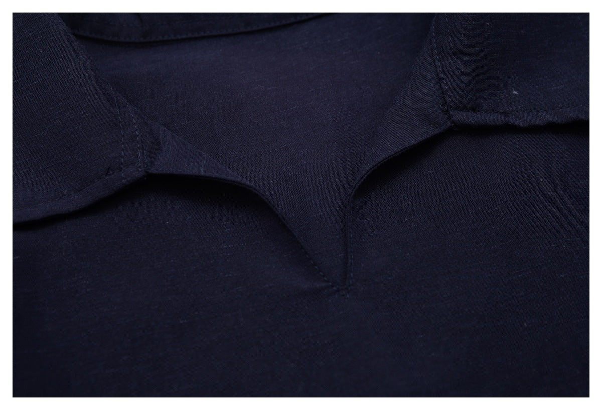 Close-up showing the dark navy shirt's collar, neckline, and stitching.