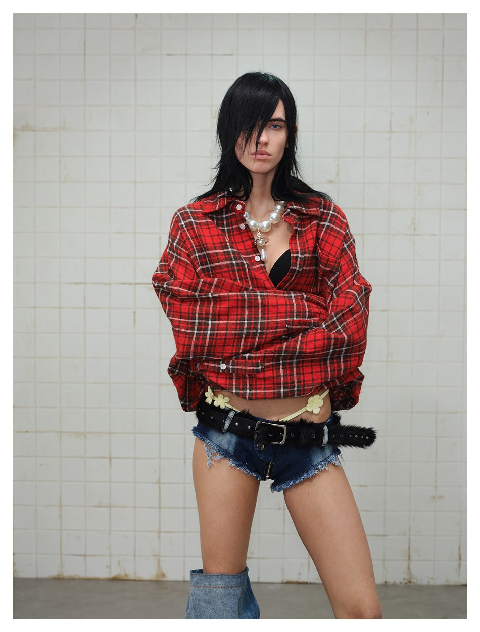 Model wearing a red, black, and white plaid button-up shirt with long sleeves.