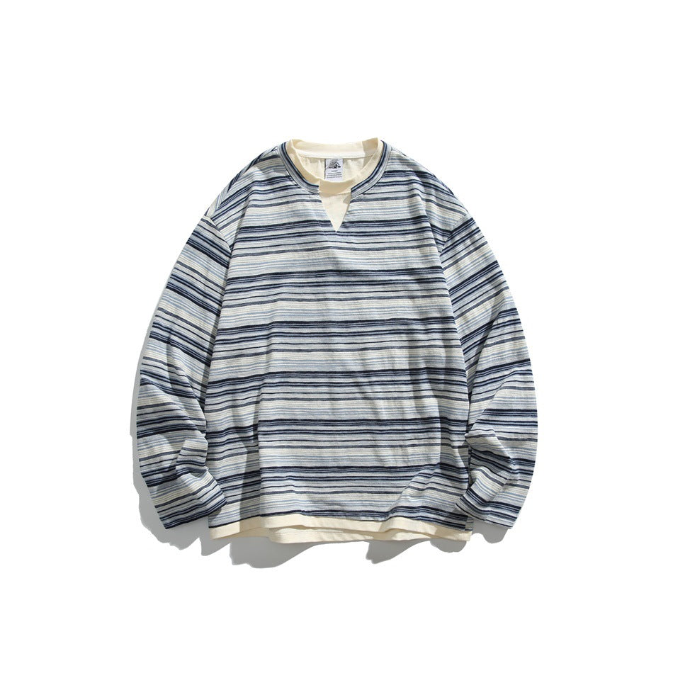 Navy and light blue striped long-sleeve sweatshirt with notched V-neck and cream layered hem, flat lay