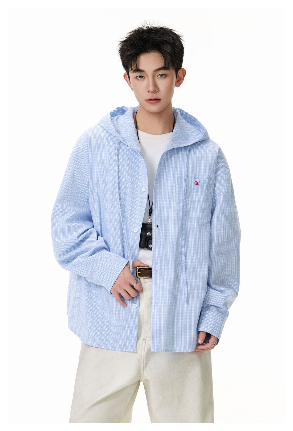 Close view of a model in a light blue check hooded shirt with chest pocket, drawcords and buttoned front
