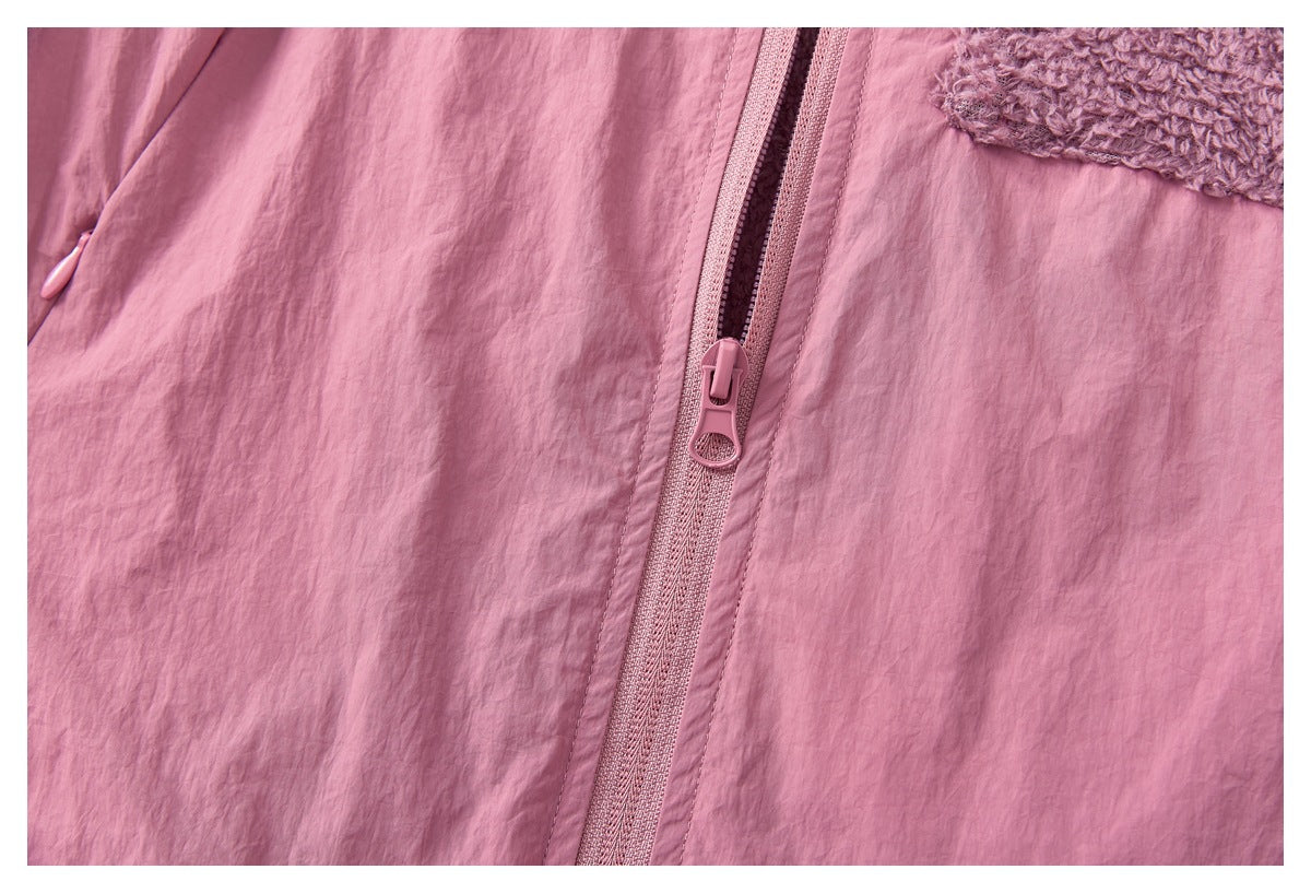Close-up of the pink jacket's front zipper and pull, with part of a fuzzy mauve pocket visible.