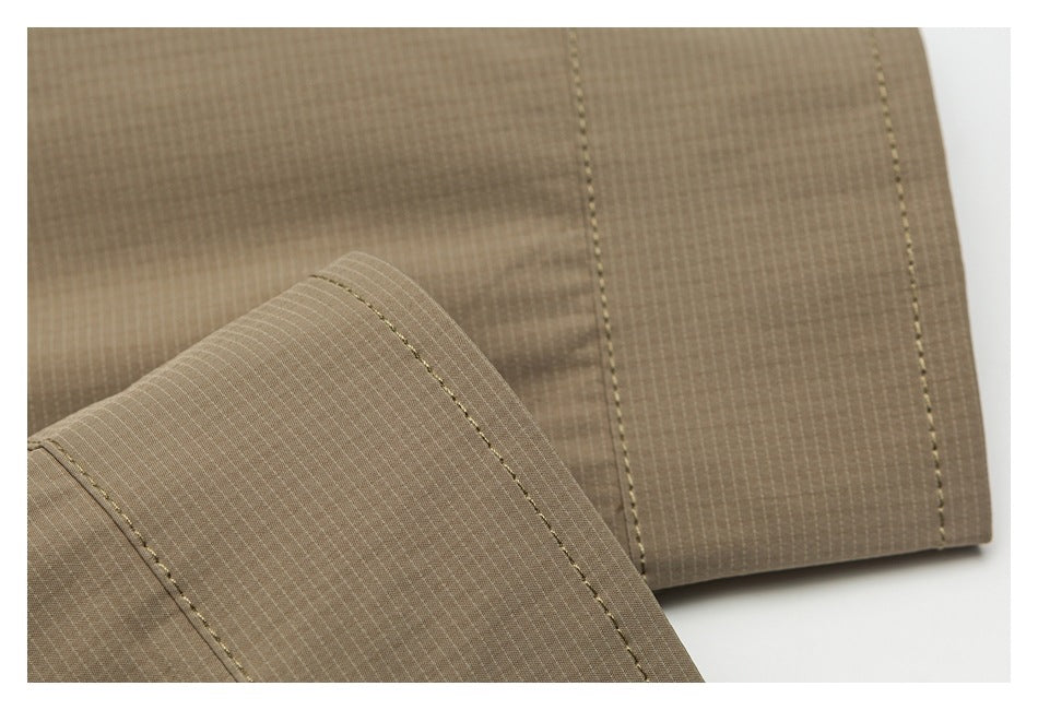 Close-up of taupe fabric panels with parallel stitching and a folded edge.