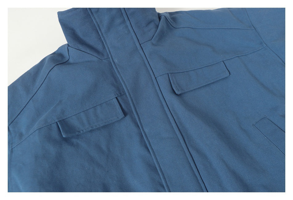 Close-up of a blue jacket front with flap chest pockets and a covered placket.