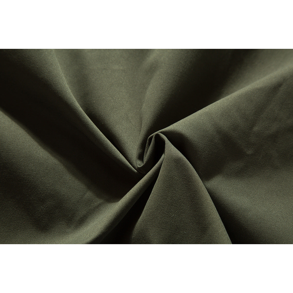 Close-up of olive-green jacket fabric gathered into folds, showing its surface texture.