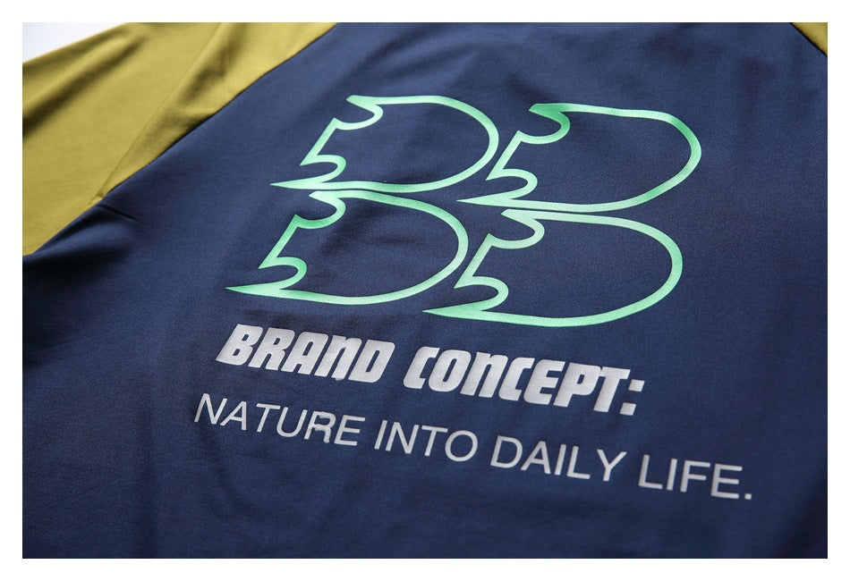 Close-up of the shirt's back print: a green outlined graphic above the white words “Brand Concept: Nature Into Daily Life.”