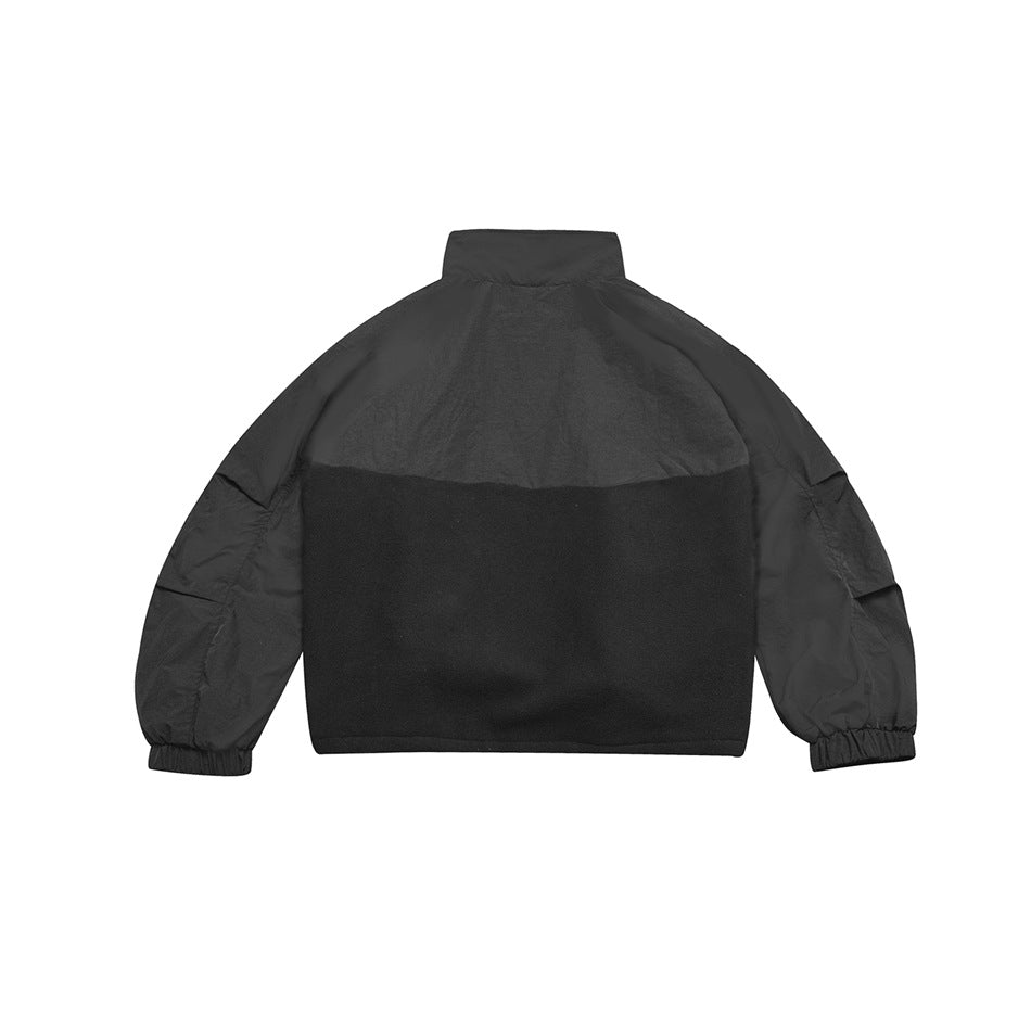 Back view of gray-black jacket with stand collar, color-block fleece-like lower panel and pleated sleeve details