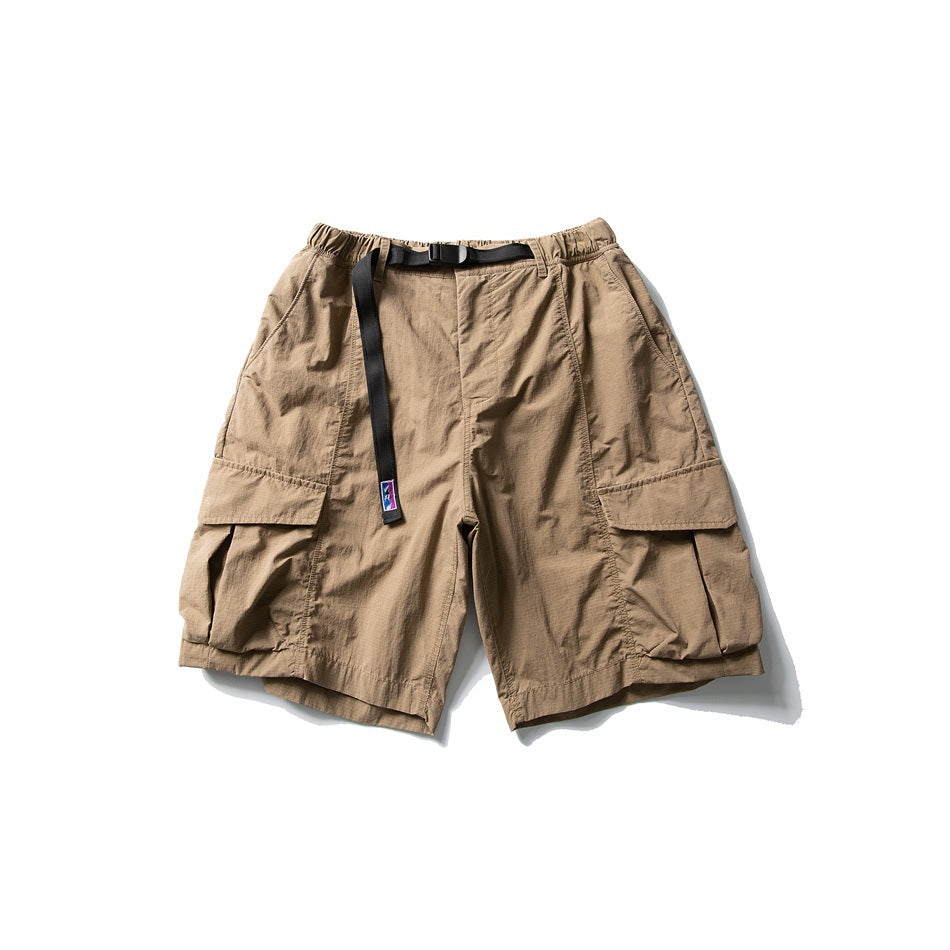 Brown cargo shorts with elastic waist, black buckle belt and large flap thigh pockets, flat lay front view