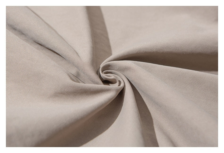 Close-up of taupe garment fabric arranged in soft folds.