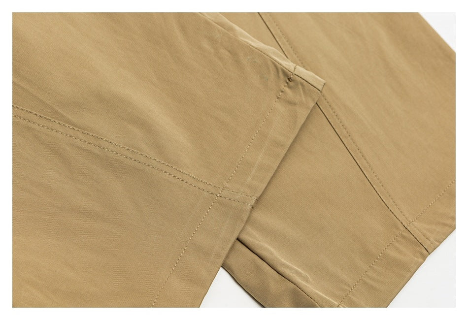 Close-up of tan pants showing intersecting panel seams and stitching.