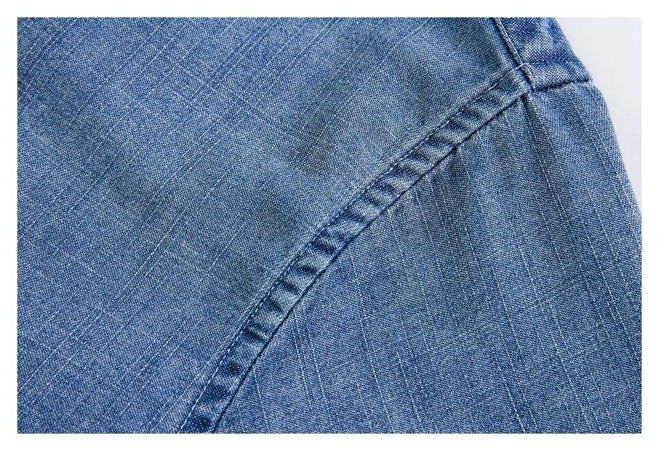 Close-up of blue denim fabric with a curved stitched seam.