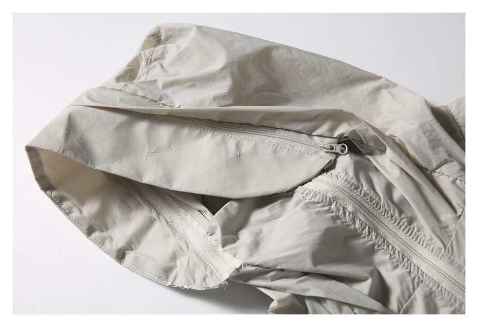 Close-up of the light beige jacket's hood brim zipper and front zipper.