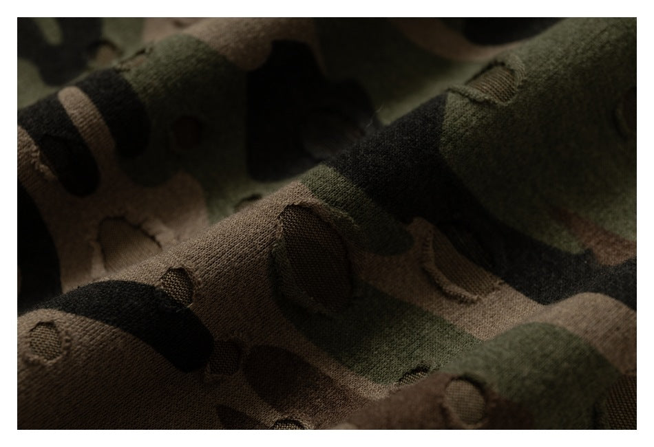 Close-up of textured green, brown, and black camouflage fabric with raised oval details.