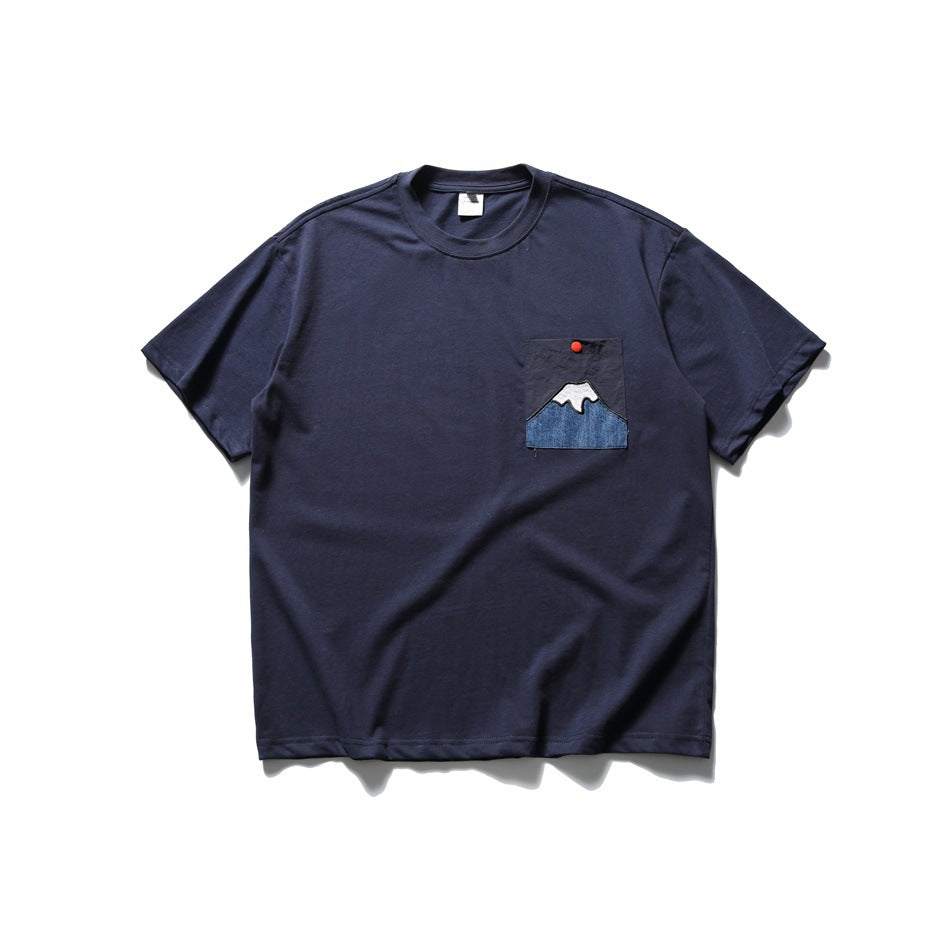 Navy crew-neck short-sleeve T-shirt with a mountain appliqué chest pocket, front flat lay
