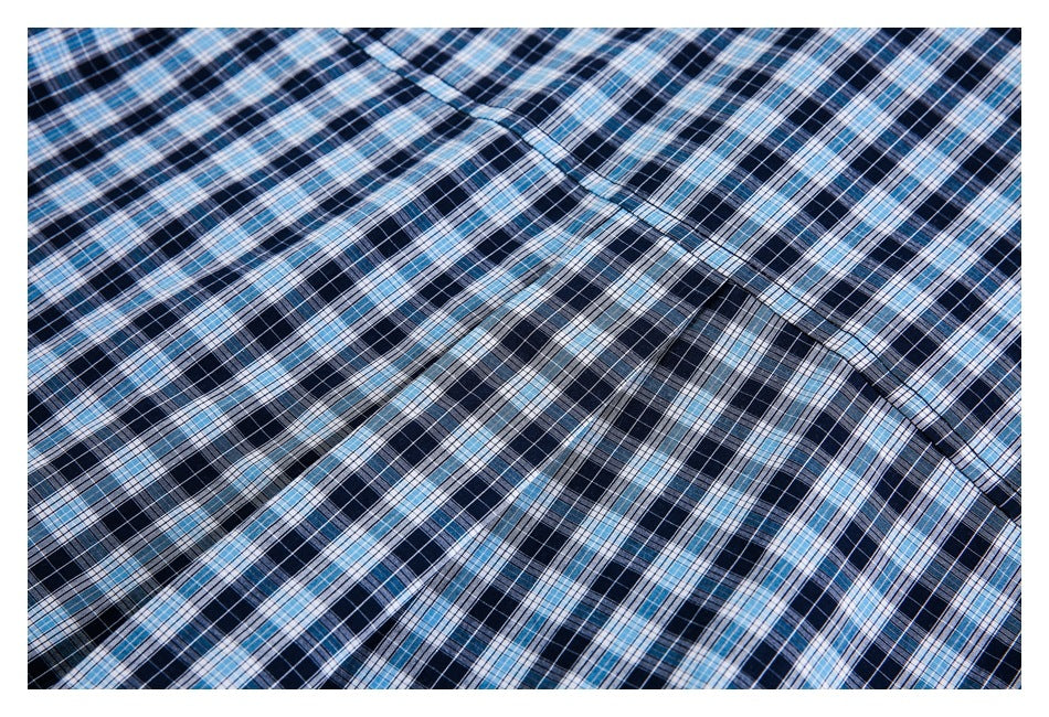 Close-up of navy, light blue, and white plaid fabric with a curved stitched seam.