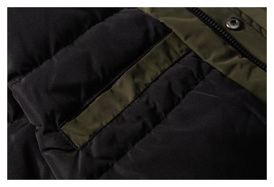 Close-up of a black quilted jacket pocket with olive trim, zipper, and snap.